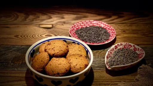 Wegańskie ciasteczka w misce, z ziarnami kakao na drewnianym stole. Vegestyl.