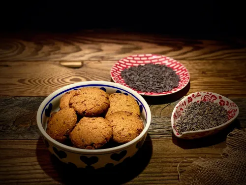 Wegańskie ciasteczka w misce, z ziarnami kakao na drewnianym stole. Vegestyl.